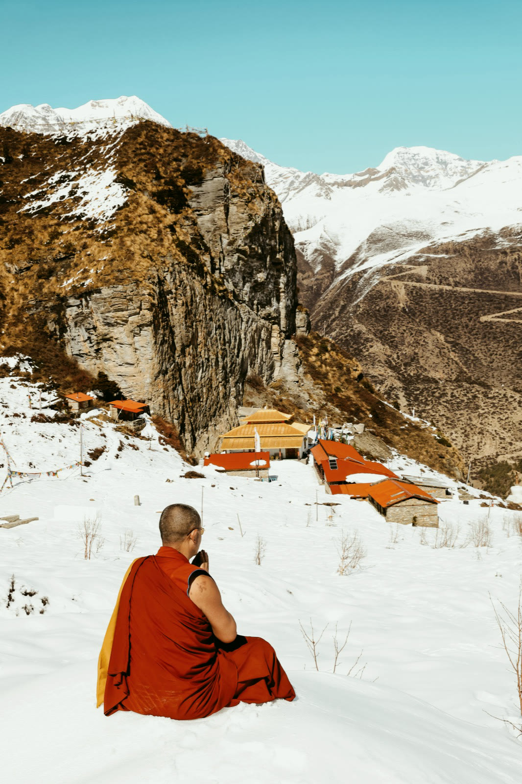 僧人在雪地中面向寺院靜坐
